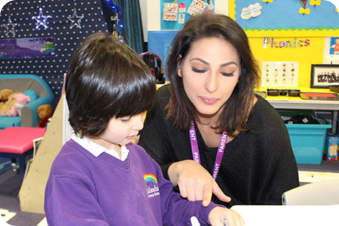 Teacher supporting a pupil in class