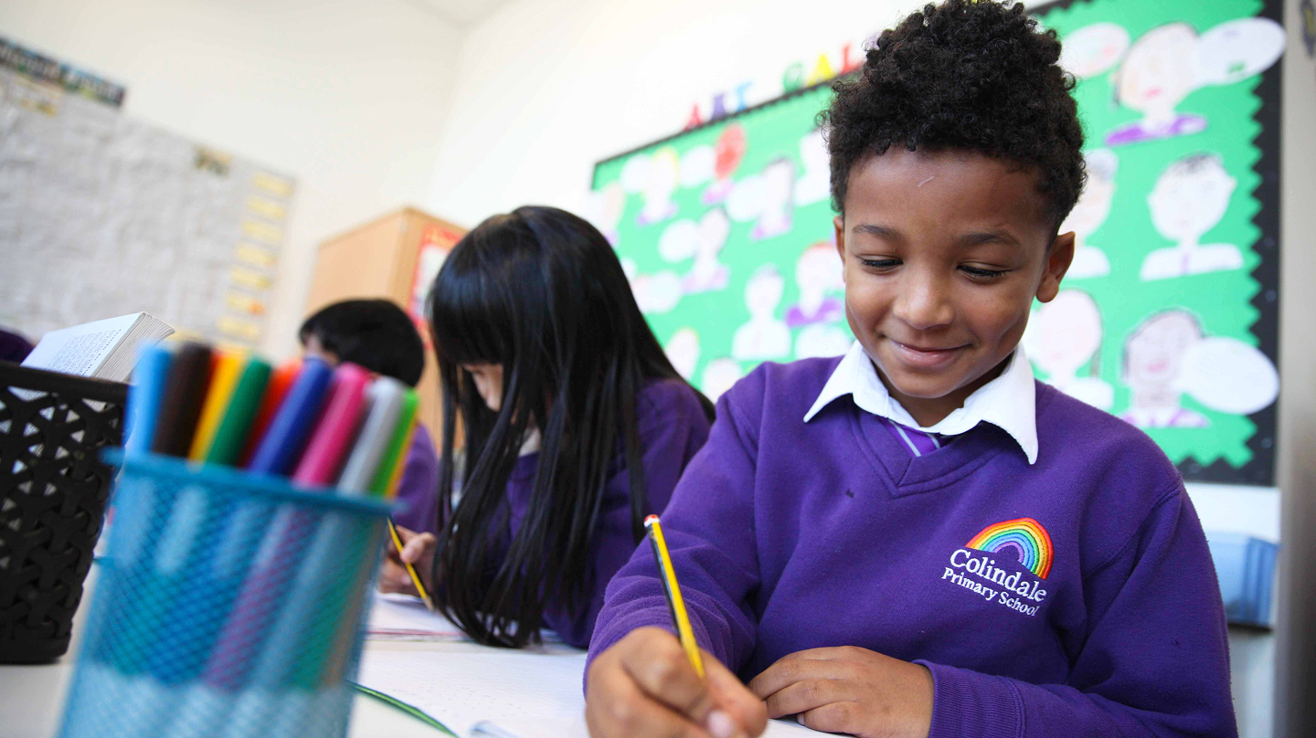 Children drawing at their desks in a classroom