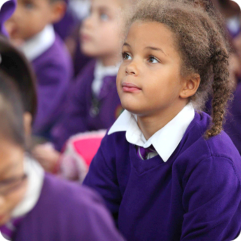 Pupil in Colindale Primary uniform paying close attention in class